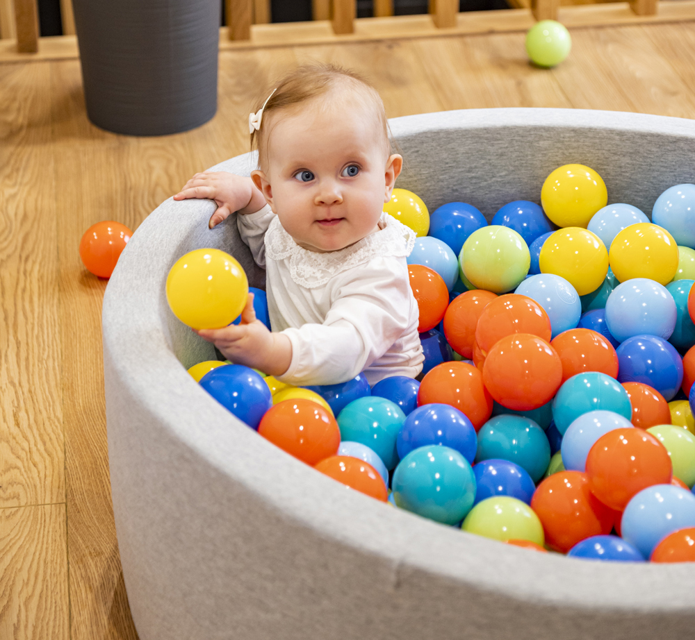 A little girl in the pool with coloured balls