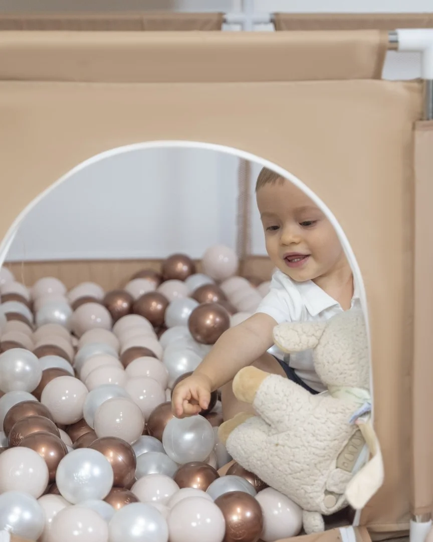 Baby in a playpen with balls