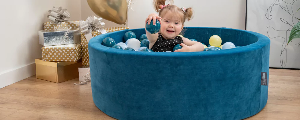 A little girl in the pool with coloured balls